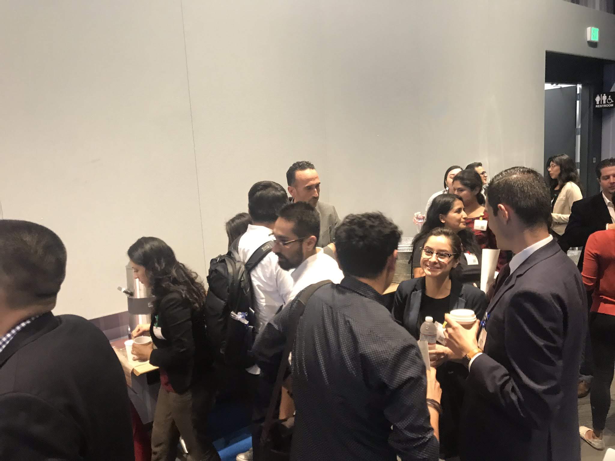 A crowded networking conversation at the symposium